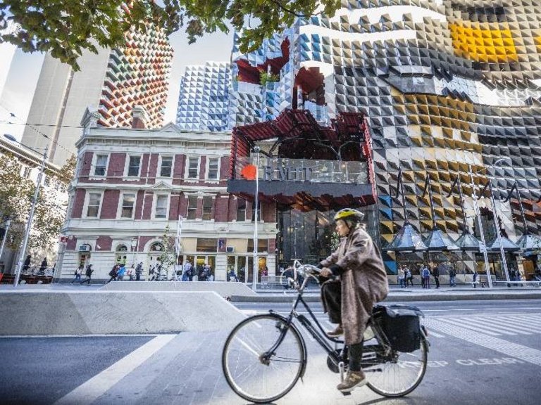 Eine Frau fährt mit dem Fahrrad durch die Creative City Melbourne