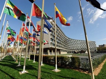 Blick auf das UNESCO Headquarter in Paris mit den Flaggen verschiedener Staaten im Vordergrund