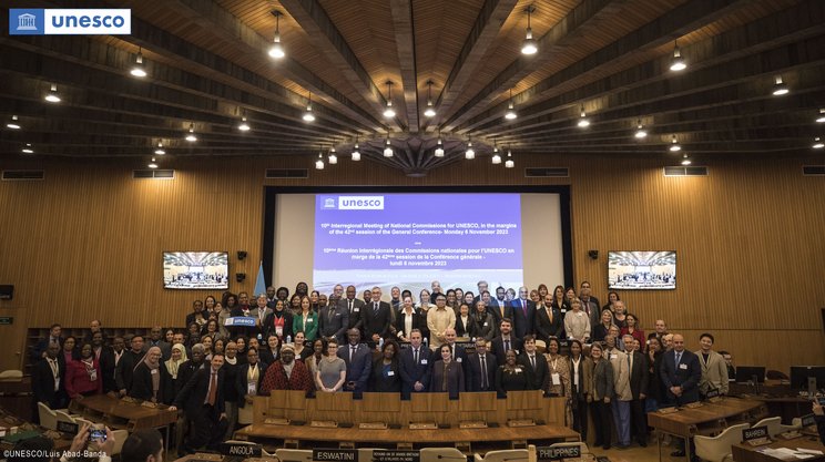 Zahlreiche Vertreterinnen und Vertreter der UNESCO-Nationalkommissionen stehen gemeinsam für ein Gruppenfoto im Plenarsaal der UNESCO. 