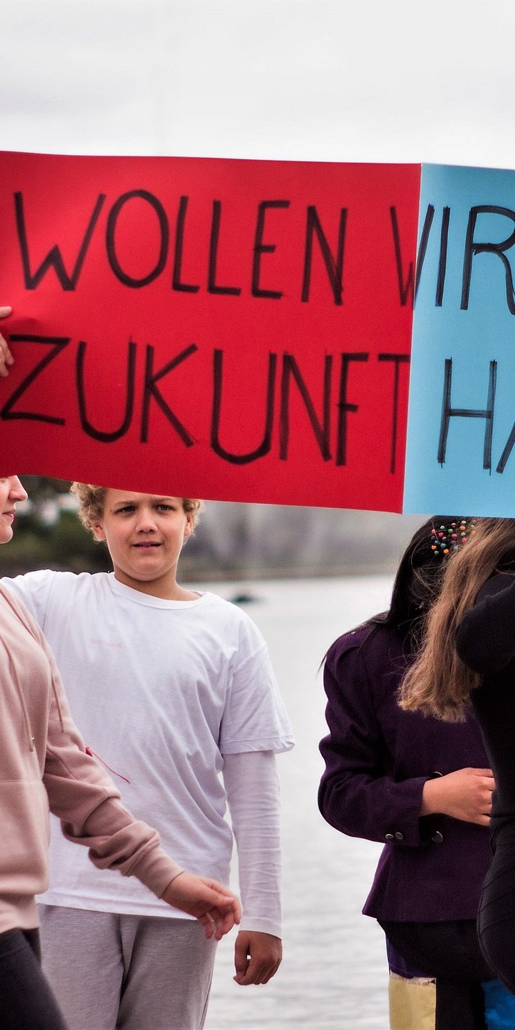 Teilnehmende des Jugendprojektes KinderKulturKarawane halten ein Schild mit der Aufschrift "Wollen wir diese Zukunft haben?"