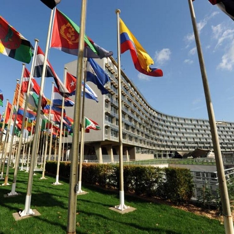 Blick auf das UNESCO Headquarter in Paris mit den Flaggen verschiedener Staaten im Vordergrund