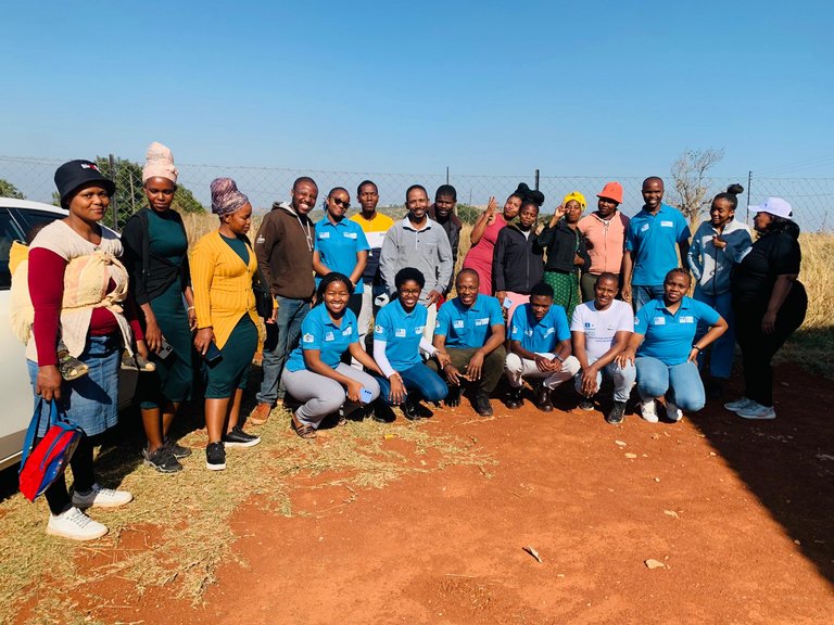 Circa 20 junge Erwachsene des MAB-Jugendnetzwerks Eswatini stehen beisammen und schauen in die Kamera. Dabei tragen sie teilweise blaue UNESCO T-Shirts