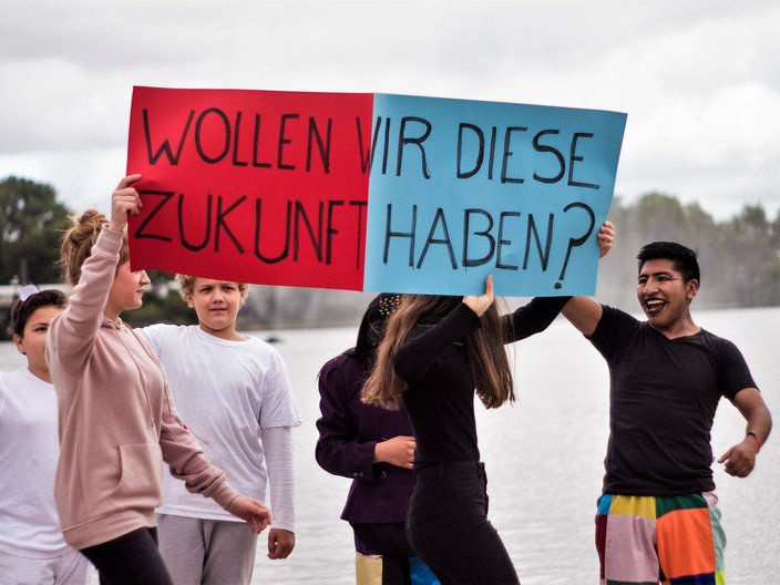 Teilnehmende des Jugendprojektes KinderKulturKarawane halten ein Schild mit der Aufschrift "Wollen wir diese Zukunft haben?"