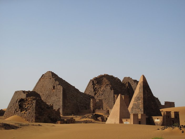 Blick auf die Welterbestätte Meroe. Man sieht pyramidenartige Gebäude, im Hinter