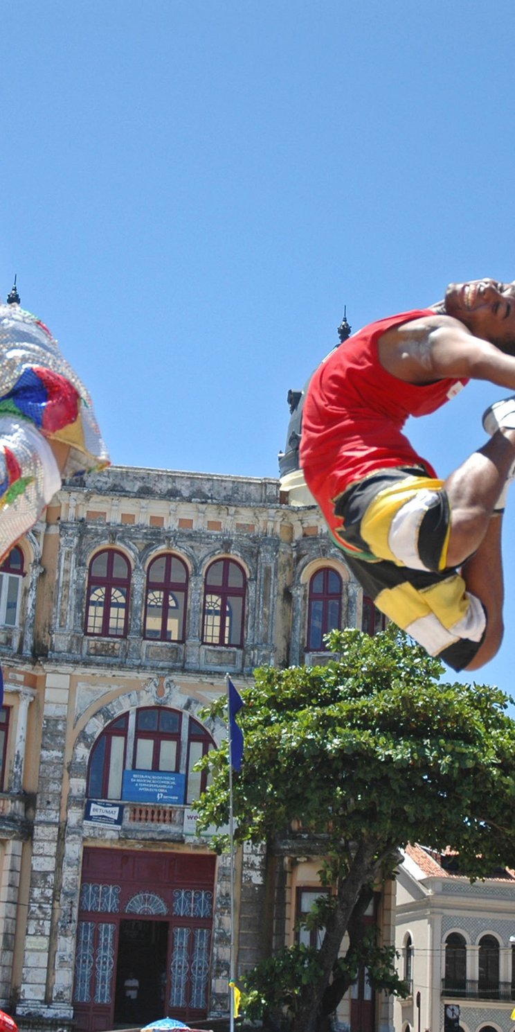 Zwei Tänzer springen beim Frevo in Recife in Brasilien in die Luft