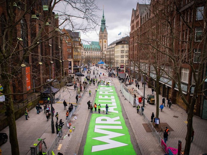 "Wir für 1,5° C" - Großer Schriftzug auf einer Straße in der Hamburger Innenstadt.