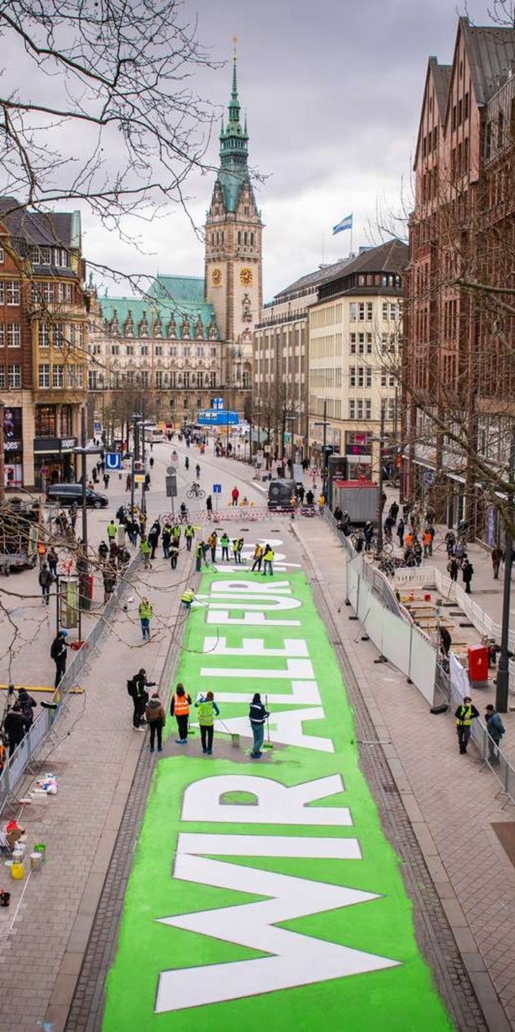 "Wir für 1,5° C" - Großer Schriftzug auf einer Straße in der Hamburger Innenstadt.