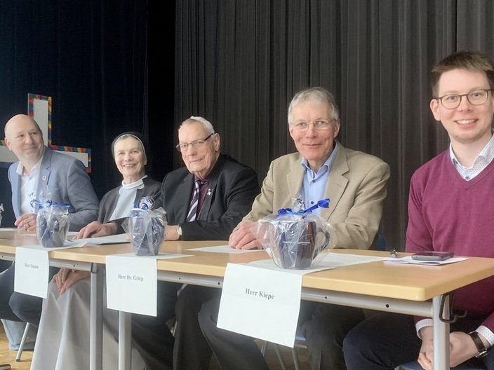 Podiumsdiskussion aus 5 Personen auf der Schulbühne.