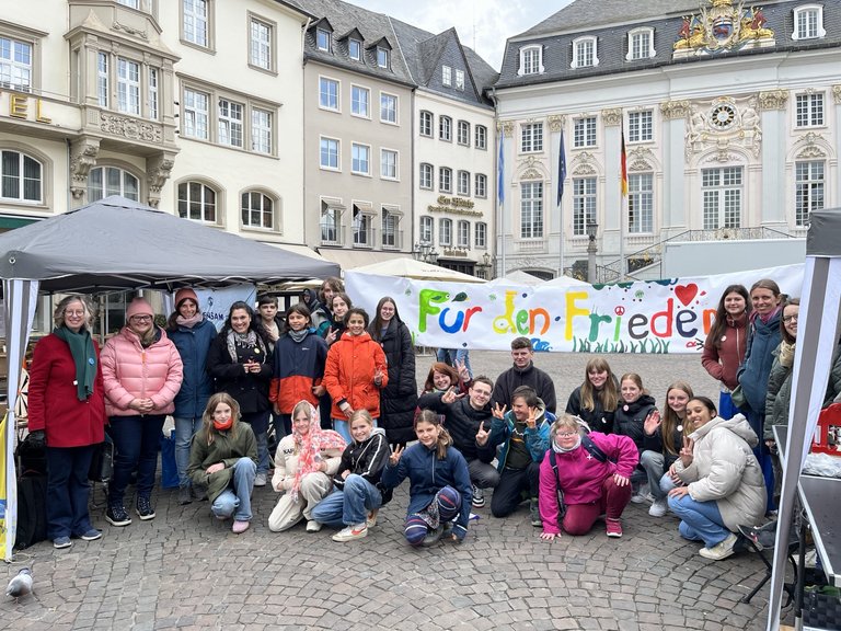 Schülerinnen und Schüler mit einem Plakat, auf dem "Für den Frieden steht"